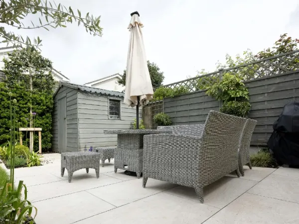 Backyard concrete patio with outdoor furniture and an umbrella