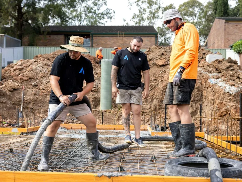 Crew pumping concrete onto a rebar mat for a slab